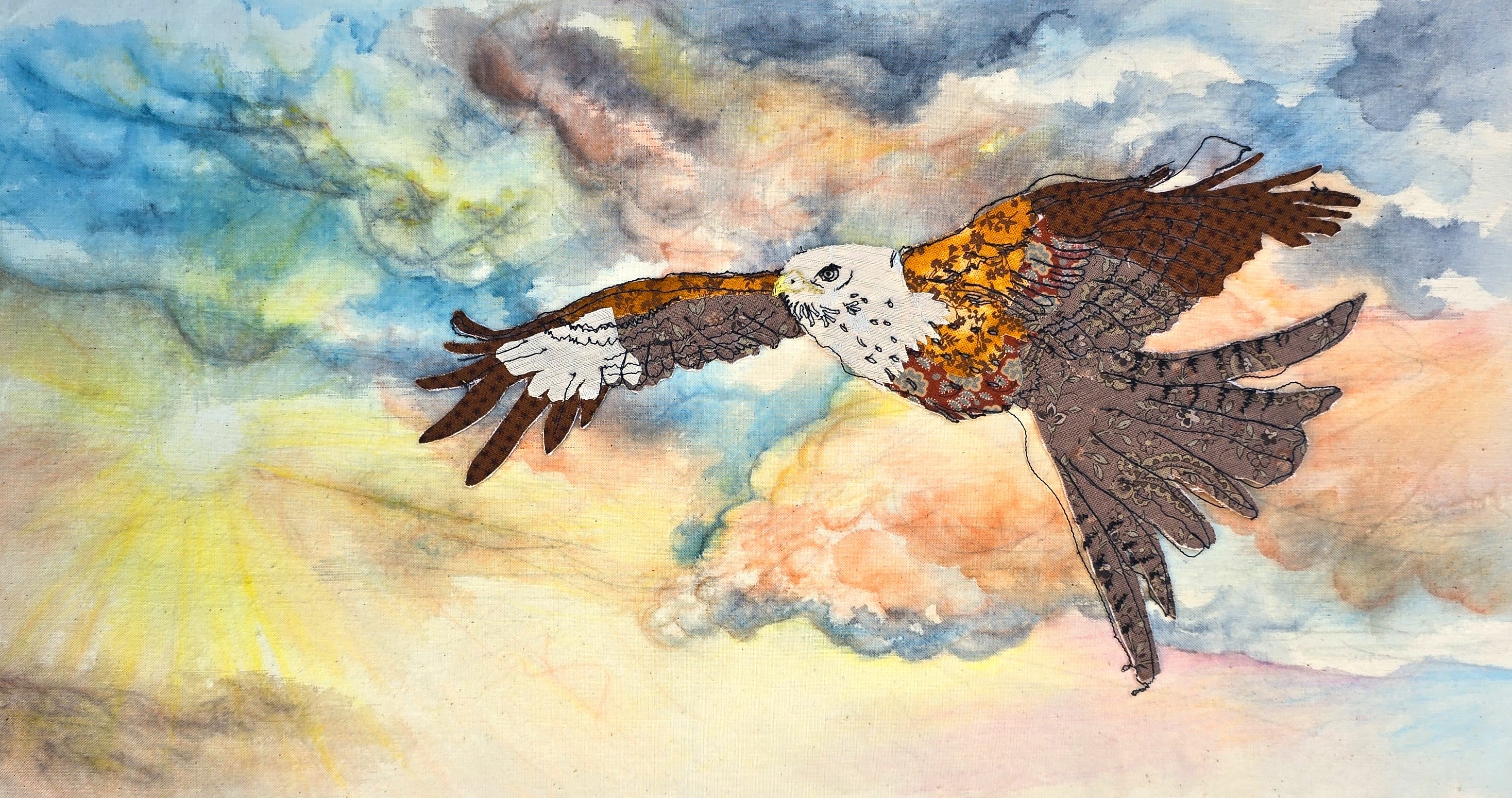 Textile art of a red kite bird made of printed fabrics with free motion embroidery details flying across a painted stormy sunset sky