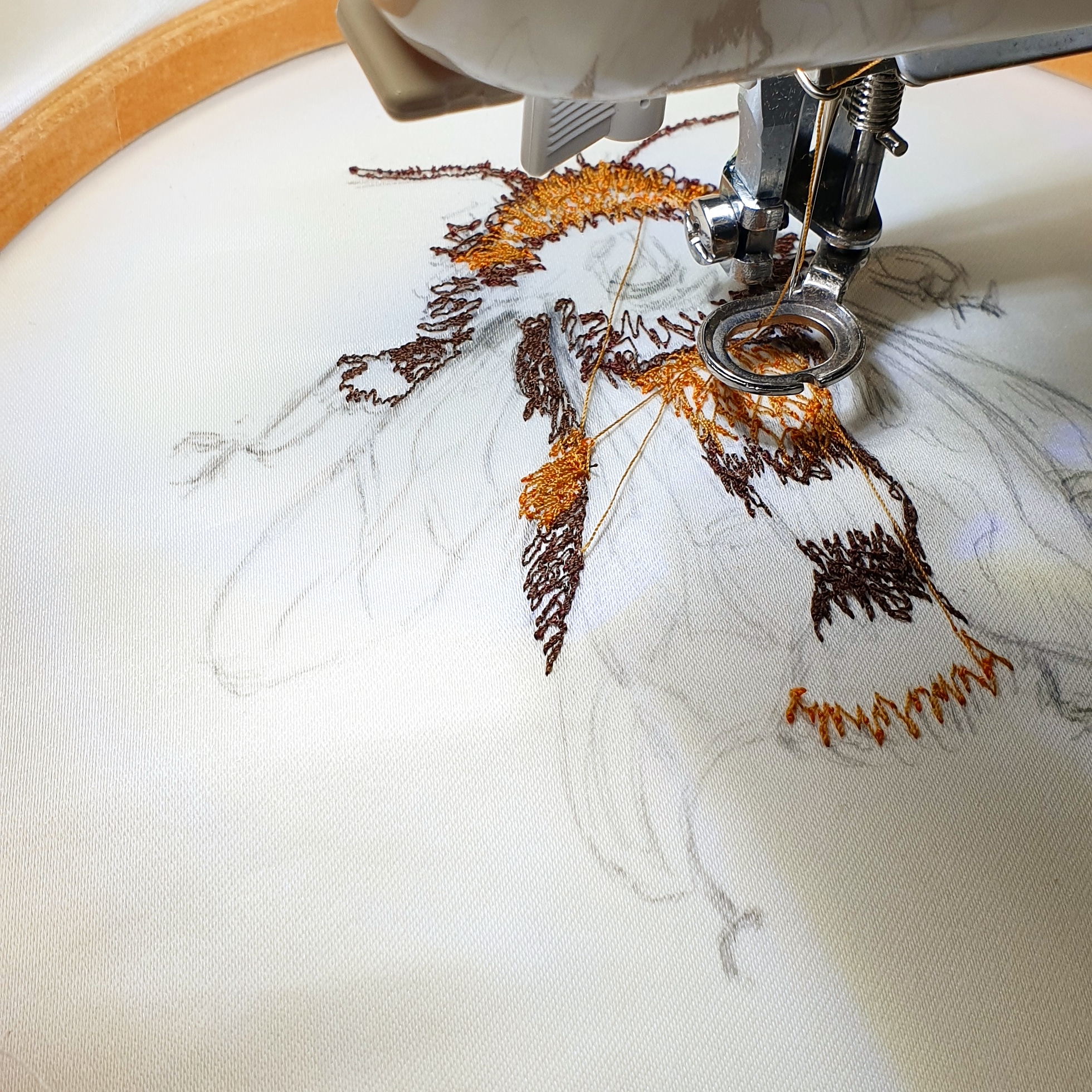 Photo of free motion embroidery in progress of a partly sewn bumblebee using a sewing machine