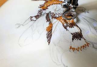 Photo of free motion embroidery in progress of a partly sewn bumblebee using a sewing machine